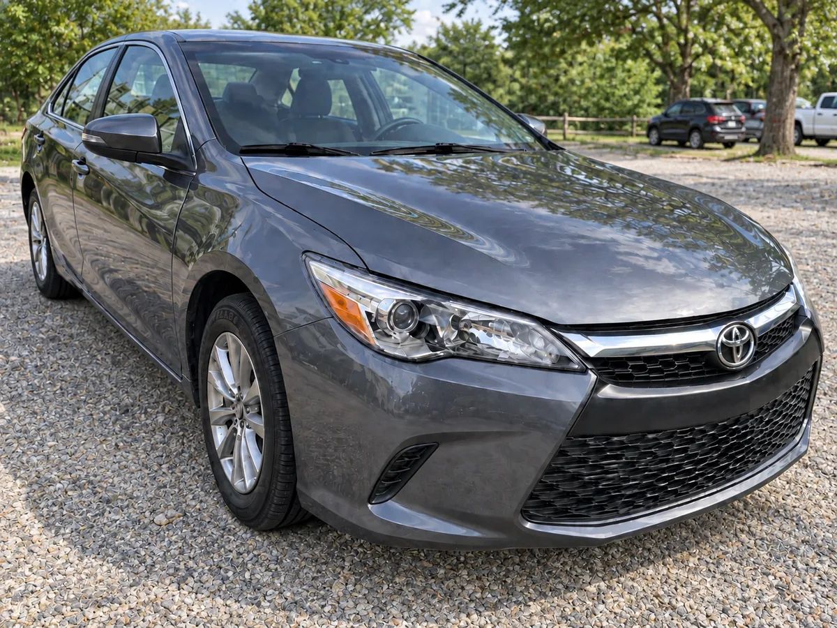 After: the grey sedan with the front bumper, fender and headlight area shown after repair.